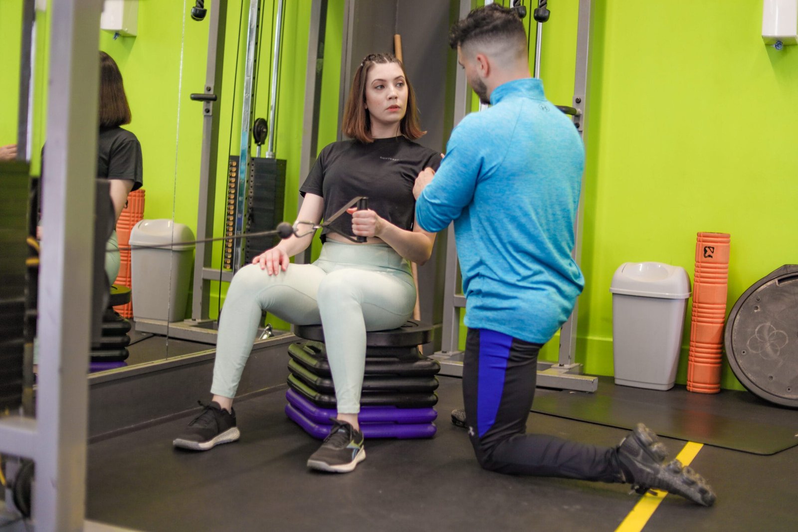 Personal trainer supporting a client during an adaptive training session